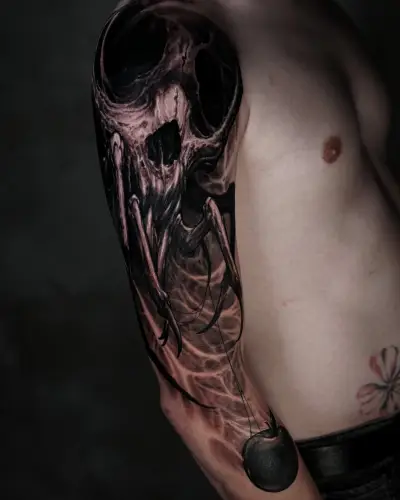 Blackwork sleeve tattoo by Andrew Stopay: a hollow-eyed creature skull with spider-like legs holding a black apple on a thread