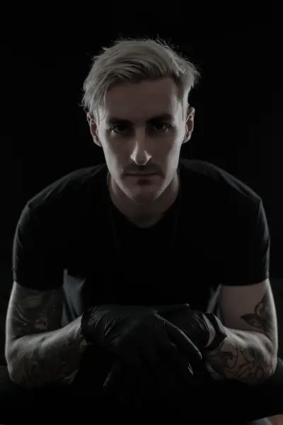 Portrait of tattoo artist Andrew Stopay in black gloves