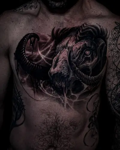 Blackwork chest piece by Andrew Stopay: a horned ram skull with glowing eye and web-like textures across the chest